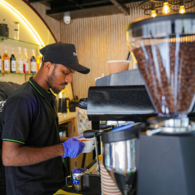 Every cup brewed with passion Barista preparing coffee using espresso machine at Hi Café